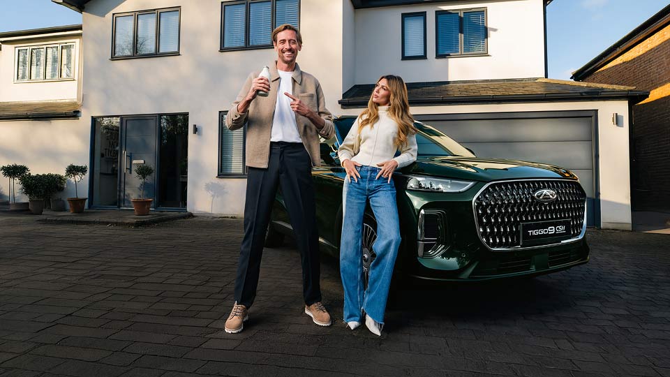 Peter Crouch and Abbey Clancy standing next to a Chery Tiggo 9
