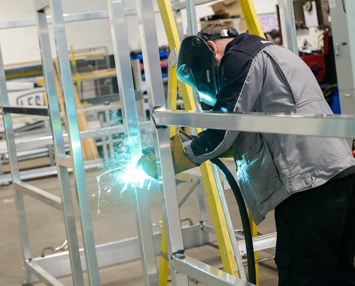 Coachbuilders employee welding in workshop