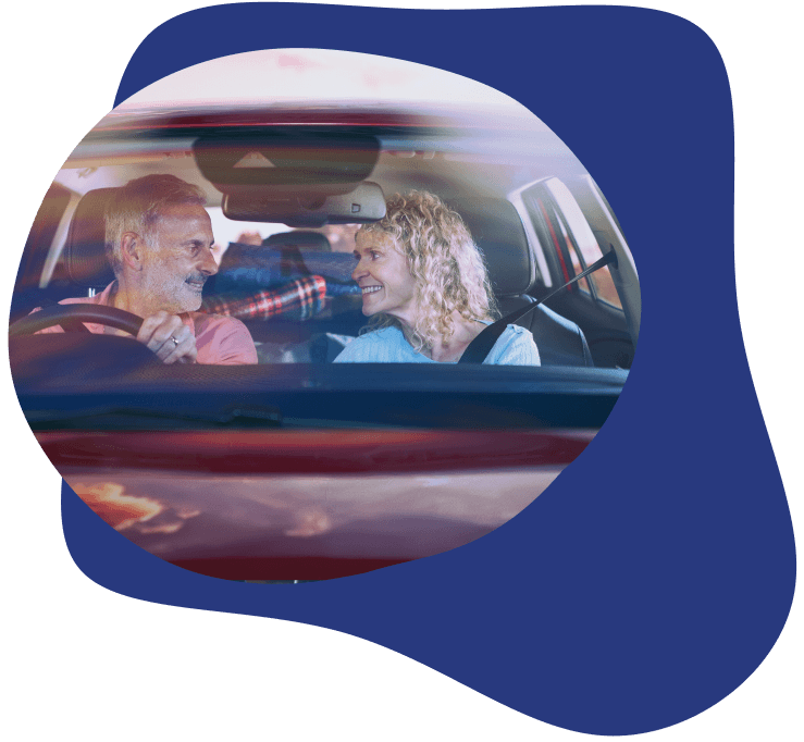 Middle-aged couple in car smiling at each other